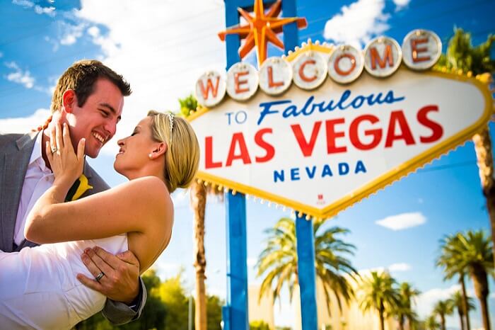 A couple poses at the welcome gate of Las Vegas