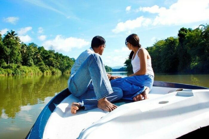 Couple enjoying a boat ride across Mahaveli river Sri Lanka