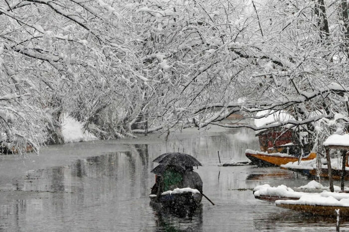 Boat covered in snow sailing in the Dal Lake