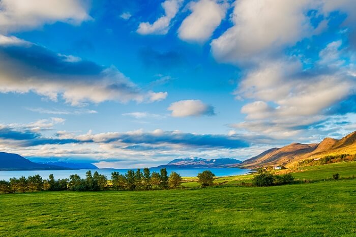 A panoramic view of the grasslands by the river in Akureyri