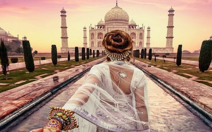 A woman posing in front of Taj Mahal