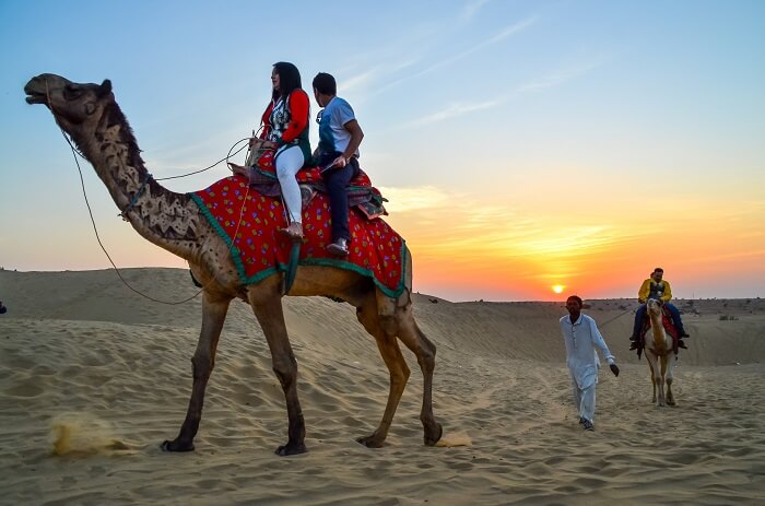 couple enjoying desert camel safari in Jaisalmer, India