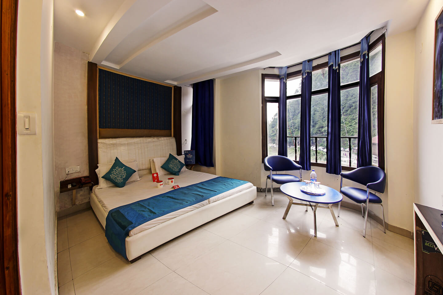 A king size bed in a room with a wide glass window