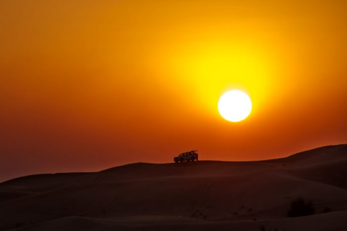 Travelers watching sunset during desert safari in Dubai