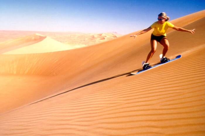 A traveler enjoying sand skiing during desert safari in Dubai