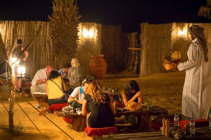 Travelers enjoying buffet dinner during desert safari in Dubai