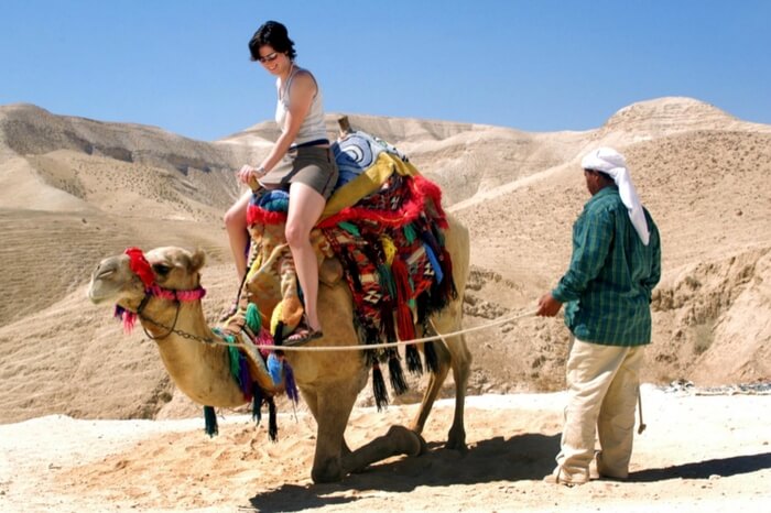 A tourist riding a camel during desert safari in Dubai
