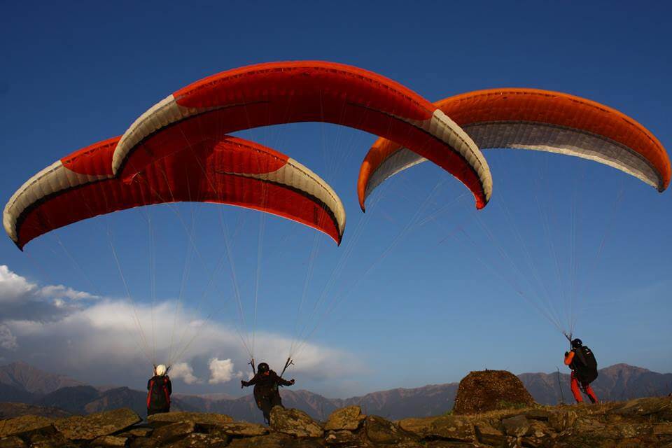 three guys paragliding in Bir Billing