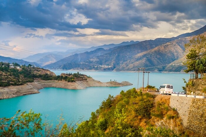 A bus heading to Kanatal with Tehri Dam is the background