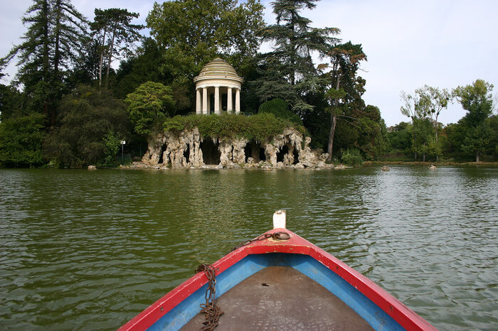 a rowboat in a river in front of temple of love