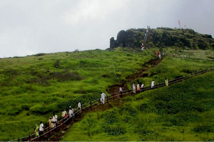 Tourists trekking to the top of Kalsubai in Maharashtra during monsoon