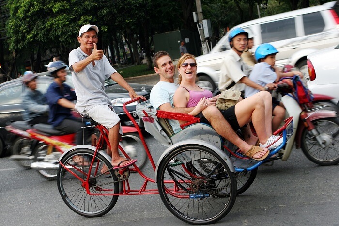 A couple taking a city tour in a cyclo in Hanoi