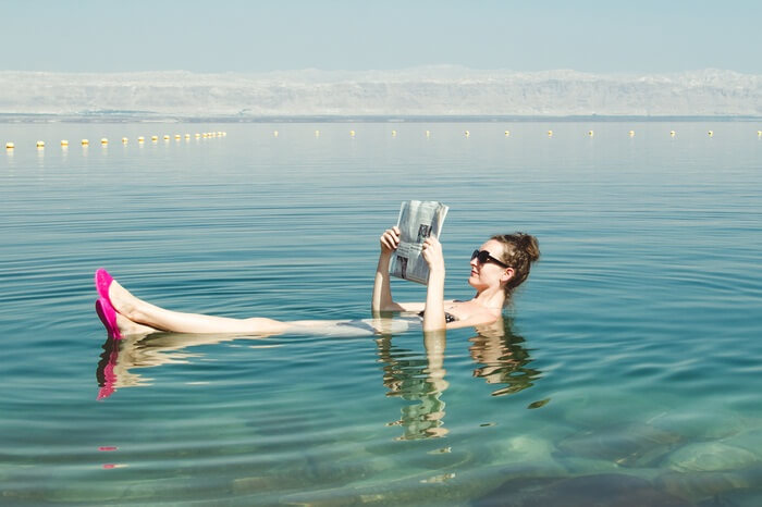 A woman reading newspapaer while floating in the Dead Sea