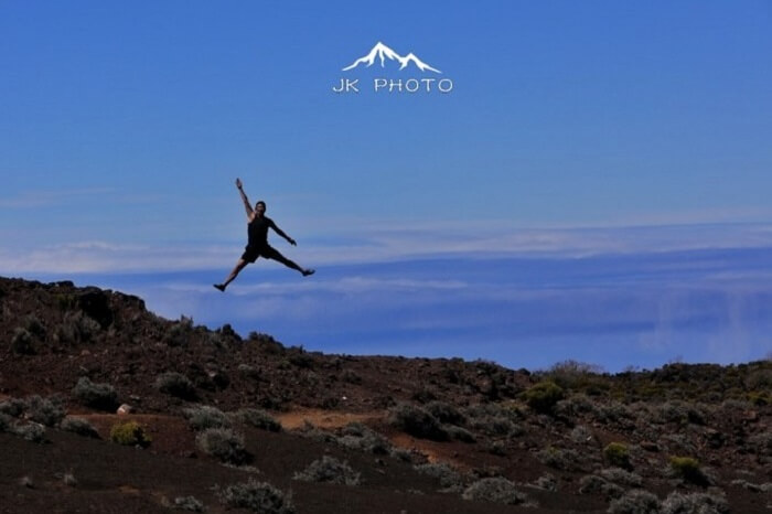 man jumps near a volcano in Reunion Island, France