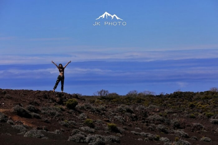 female jumps near a volcano in Reunion Island, France