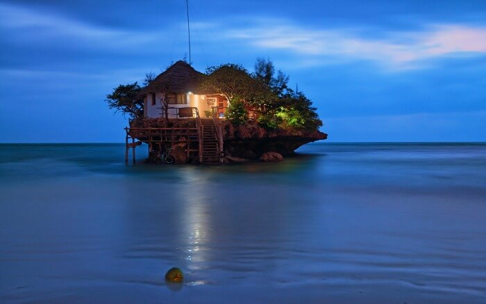A hotel in the middle of water on a rock