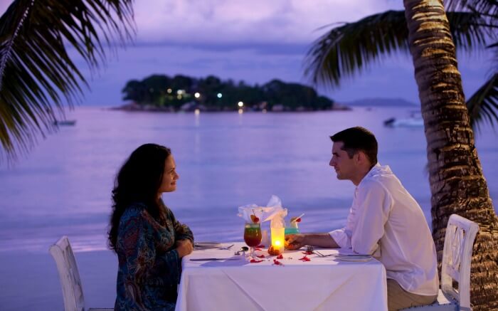 Couple dining by the beach during their safari honeymoon in Tanzania