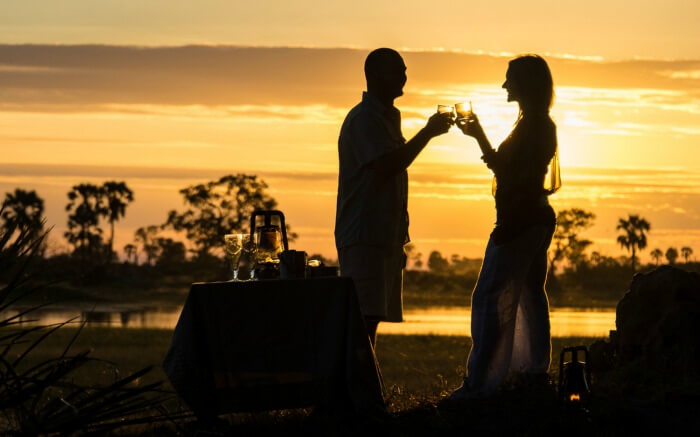 Couple raising a toast during their honeymoon in Botswana