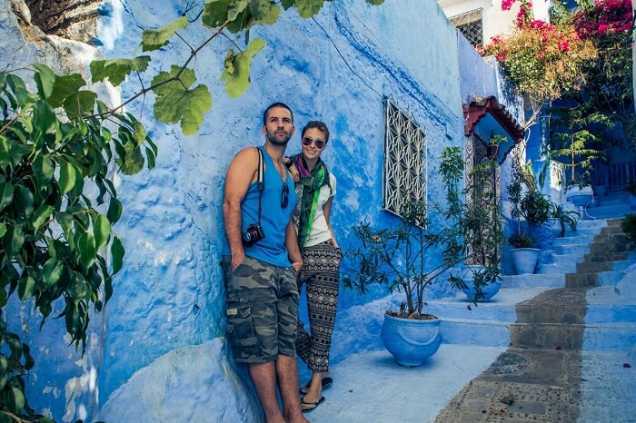 A couple posing in the blue town of Chefchaouen in Morocco