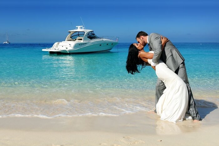 A couple kissing on a beach on their honeymoon in cayman islands