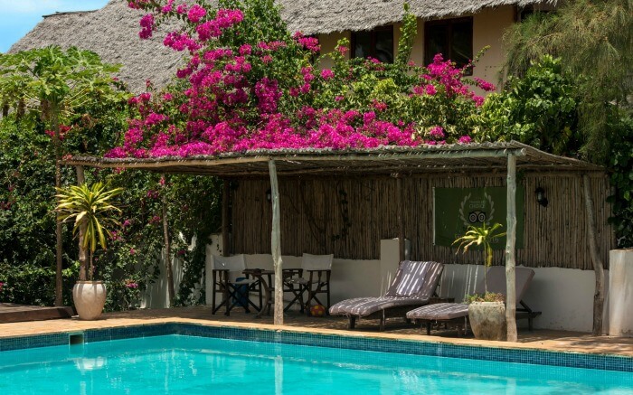 pool area of Zanzibar Retreat hotel decorated with bougainvillea flowers