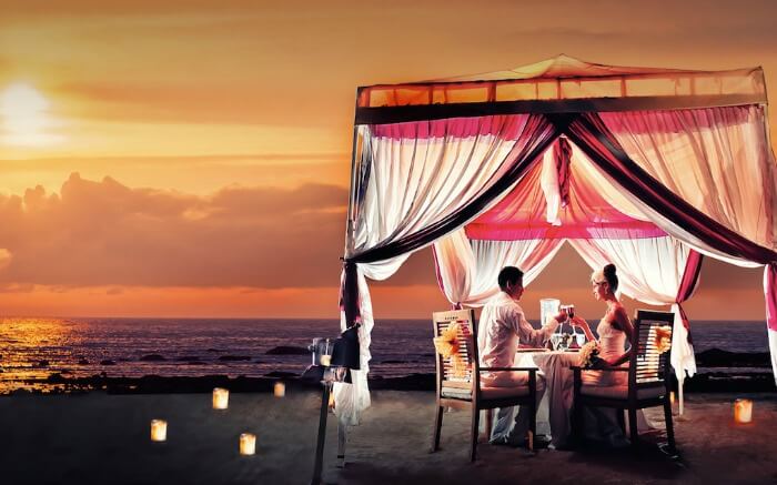 A couple having a romantic dinner in a tent on Kuta Beach