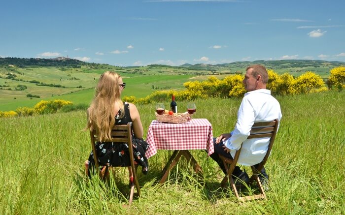 A couple sitting amid fields of Tuscany