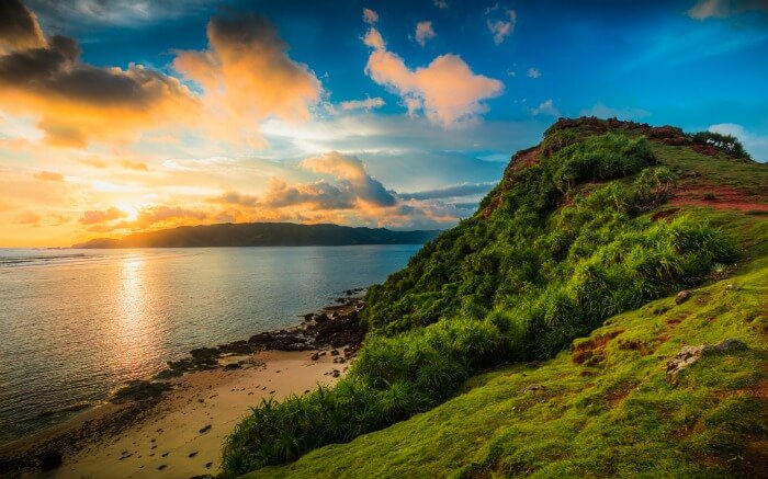A view of a cloudy sky during sunset from a cliff in Kuta
