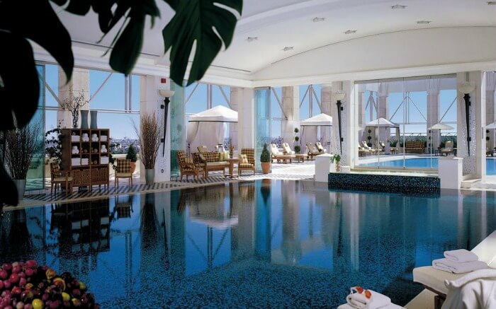 An indoor pool with sundecks and cabanas around