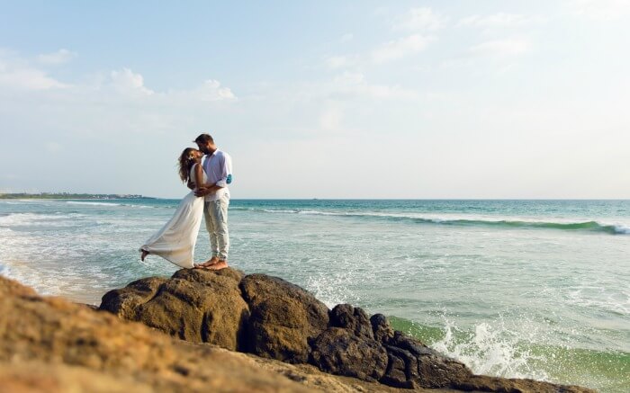 Couple kissing on a cliff by the sea shore in Sri Lanka