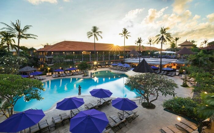 Long shot of a resort with a beautiful outdoor swimming pool and palm trees