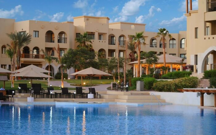 Outdoor pool with sitting area in a resort in Tala Bay