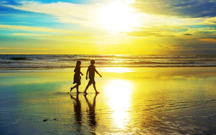 Silhouette of a couple walking on Kuta Beach during sunset