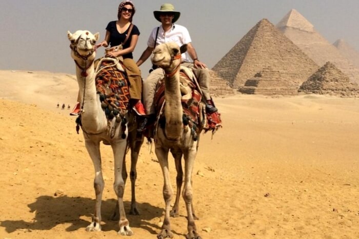 Couple enjoying a camel ride near Pyramids in Egypt