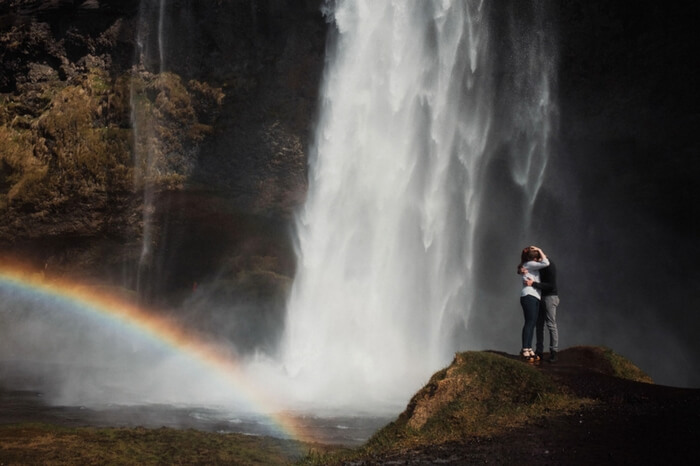Couple romancing near waterfall in Iceland