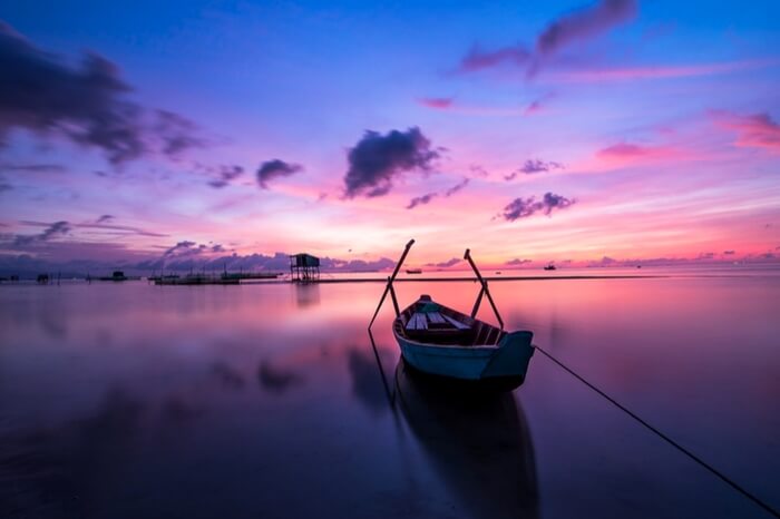 A boat docked by the sea shore in Vietnam at sunrise