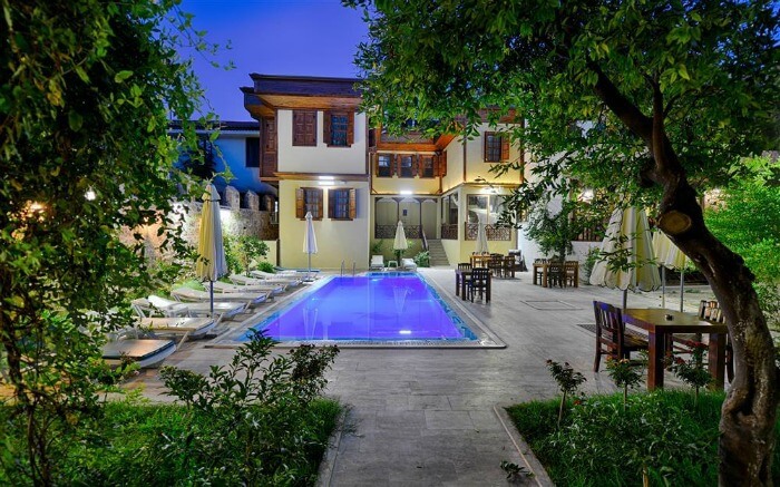an outdoor pool surrounded with trees and plants