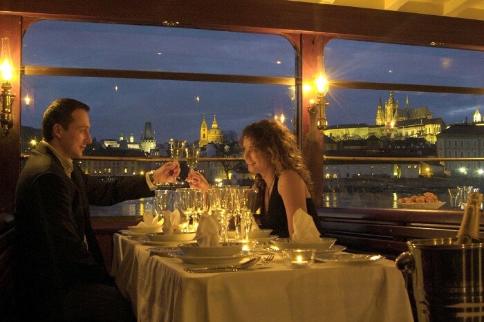 A couple enjoys a romantic dinner while cruising in the canals of Prague