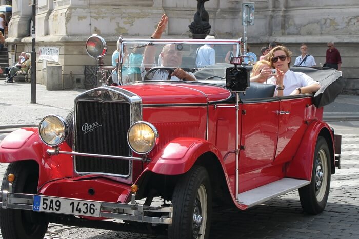 A couple takes a vintage car tour on their honeymoon in Prague