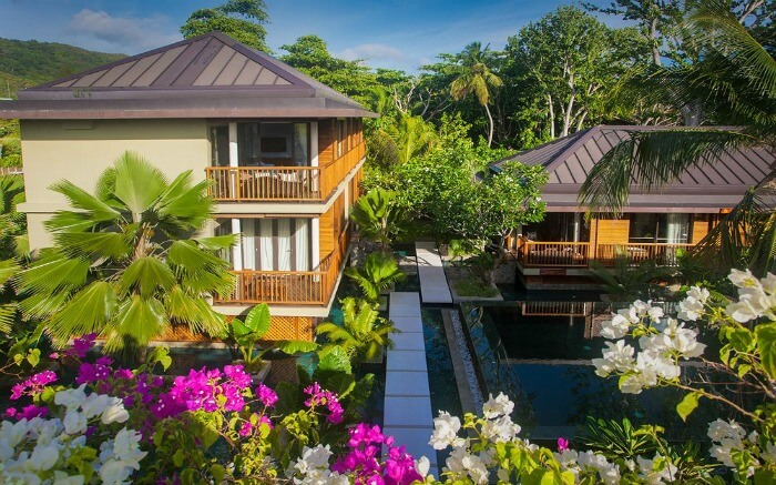 A beautiful hotel surrounded by trees and flower plants