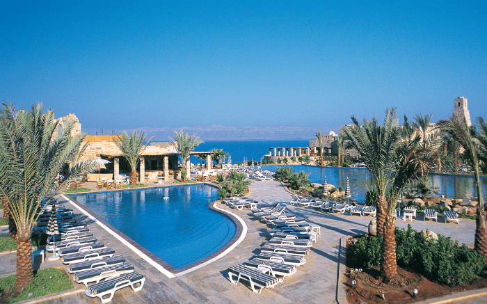 A great view of greenery surrounding the pool area of Moevenpick Resort & Spa Dead Sea overlooking the Dead Sea