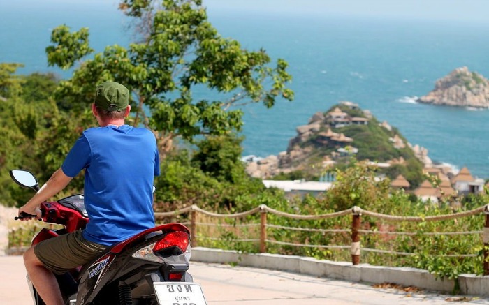A guy in blue t shirt riding a bike on an island
