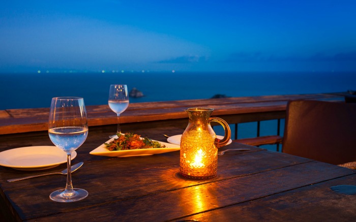 A romantic candlelit dinner table overlooking the sea