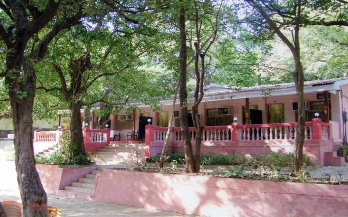A view of Adamo The Village Hotel in Matheran nestled in trees