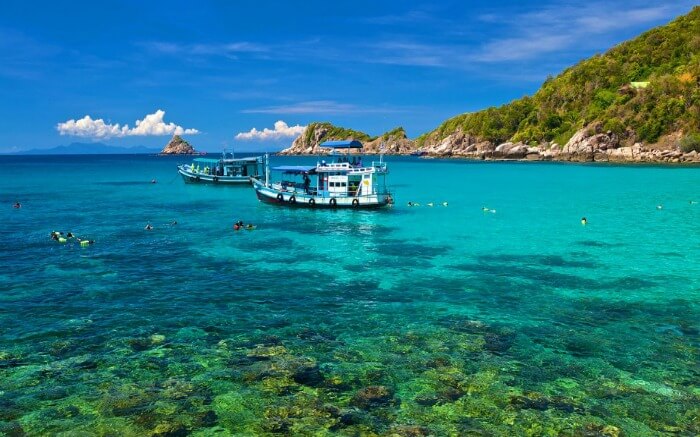 Two high-speed boats on the clear water of an island