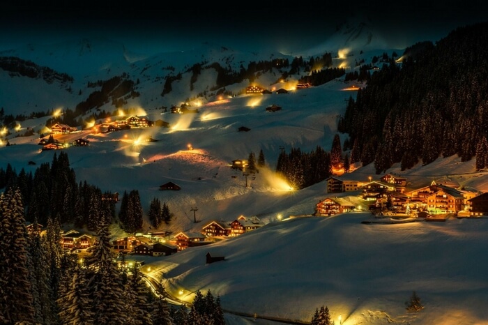 A warmly lit all-white Damuls in the heart of mountains