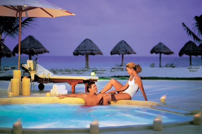 A couple on a honeymoon in Mexico relaxing in the swimming pool at Secrets Capri Riviera Cancun