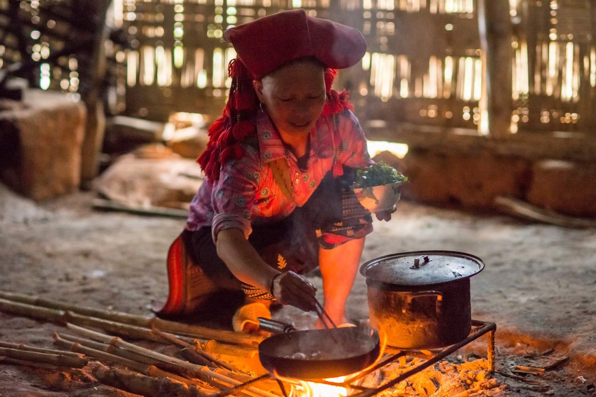 an old lady cooking food on mud stove