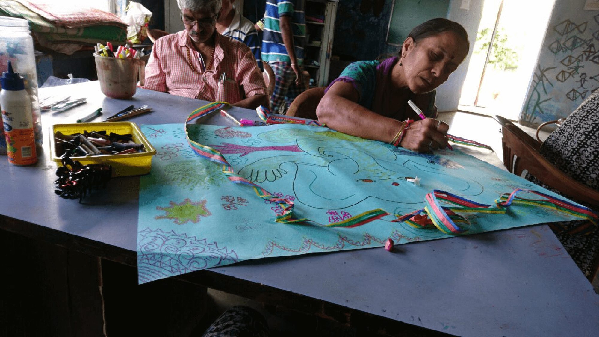 a women and an old man drawing something on a chart