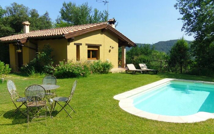 cottage like hotel with a pool on the field